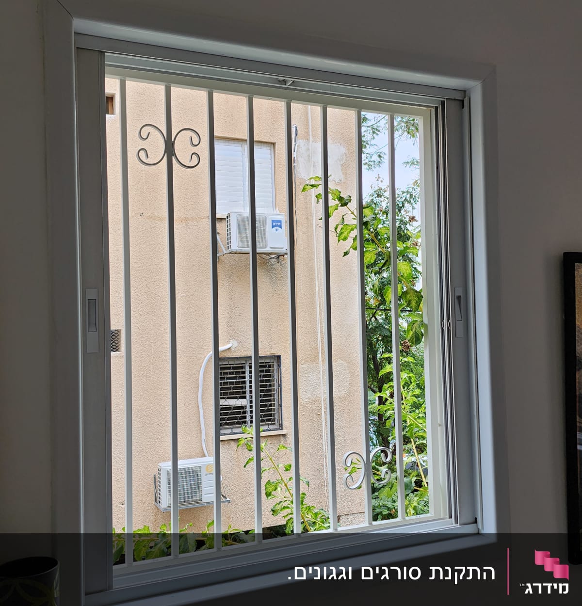 חלון עם סורגים לבנים ומסגרת לבנה